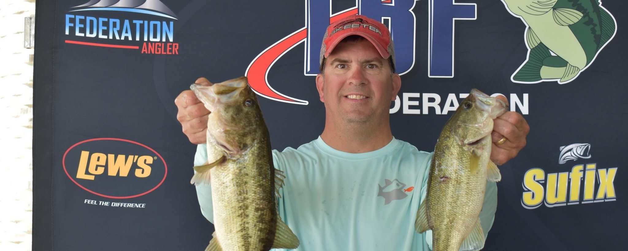 Captain Dave Morrissette holding two bass at TBF National Championship weigh-in